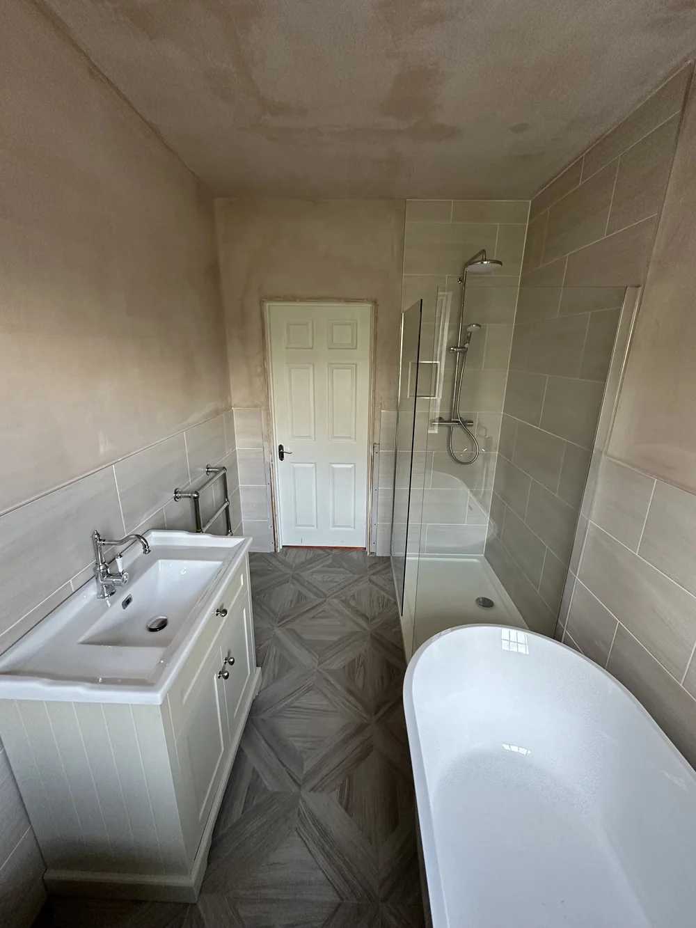 Family bathroom mid-renovation with fresh plaster, shaker vanity, walk-in shower and freestanding bath — bathroom renovation Haslemere