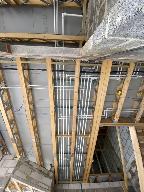 First-fix plumbing pipework rising through timber stud walls — plumber Haslemere