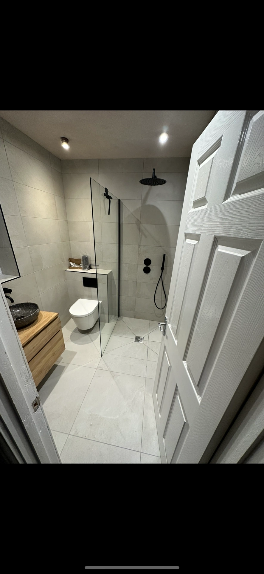 Modern wet room with oak vanity, stone vessel and matte black shower fittings — bathroom installation Haslemere