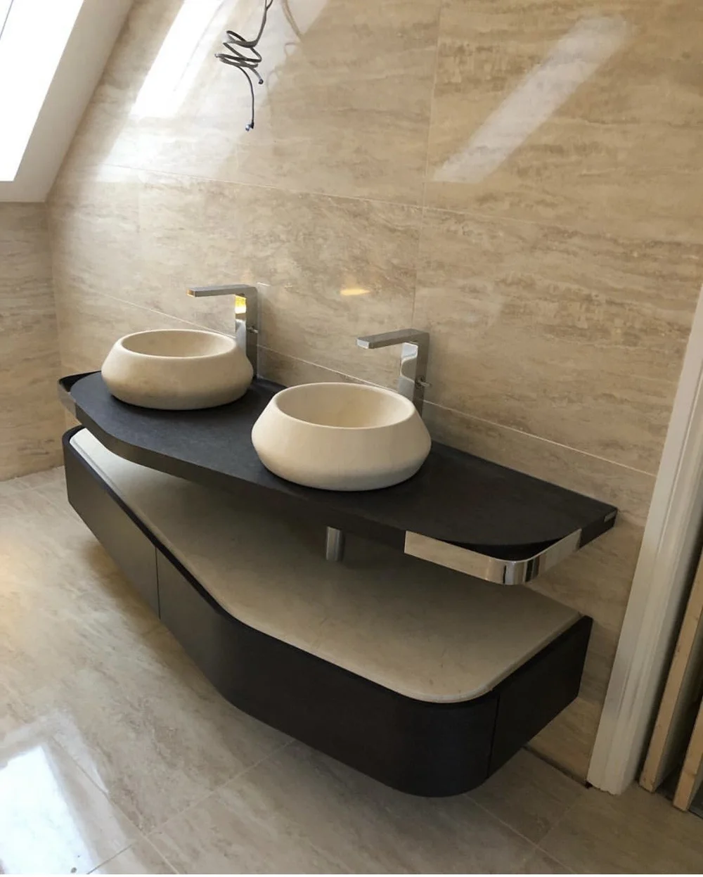Bespoke twin stone vessel basins on curved slate vanity in travertine ensuite — bathroom design Haslemere