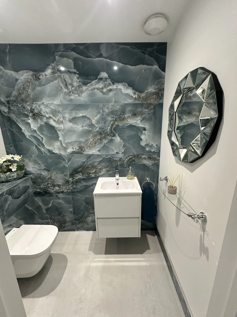 Luxury cloakroom with blue onyx feature wall, wall-hung WC and jewel-cut mirror — bathroom installation Haslemere