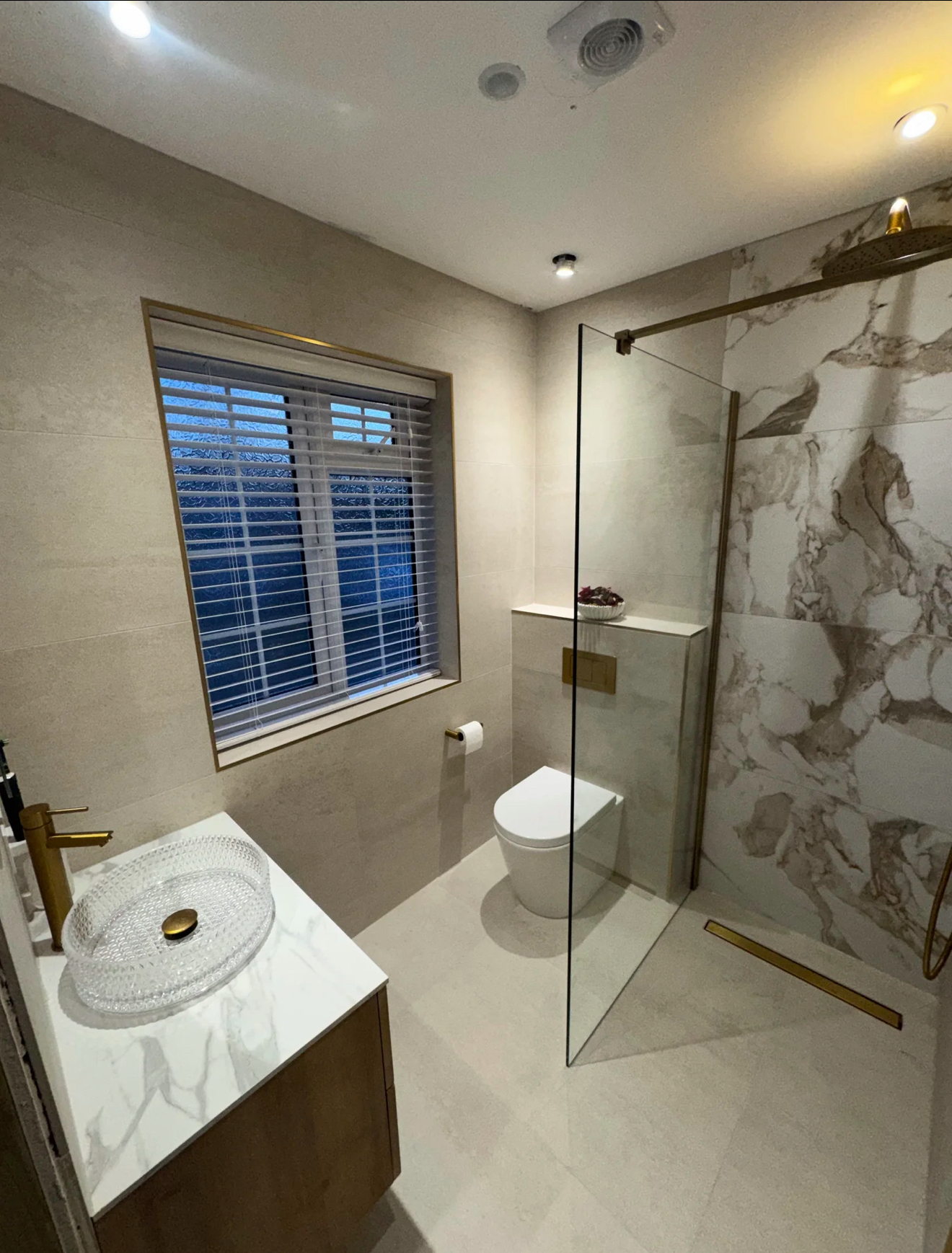 Luxury walk-in shower with marble feature wall and brushed brass fittings — Haslemere bathroom renovation