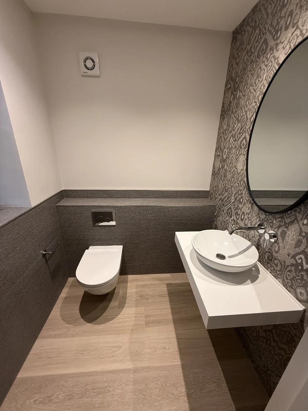 Bespoke cloakroom with patterned wallpaper, oak floor and floating vessel basin — Haslemere