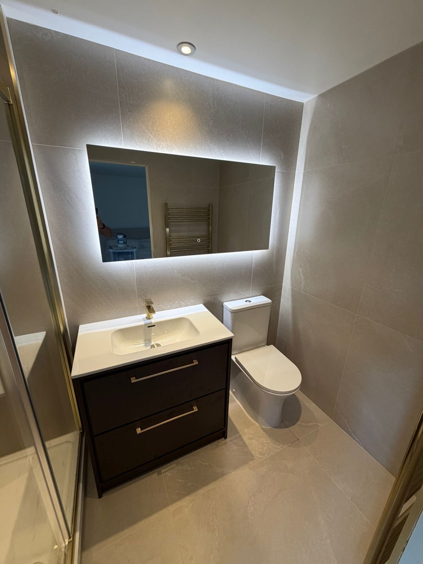 Modern bathroom vanity and WC with illuminated mirror — bathroom fitters Haslemere