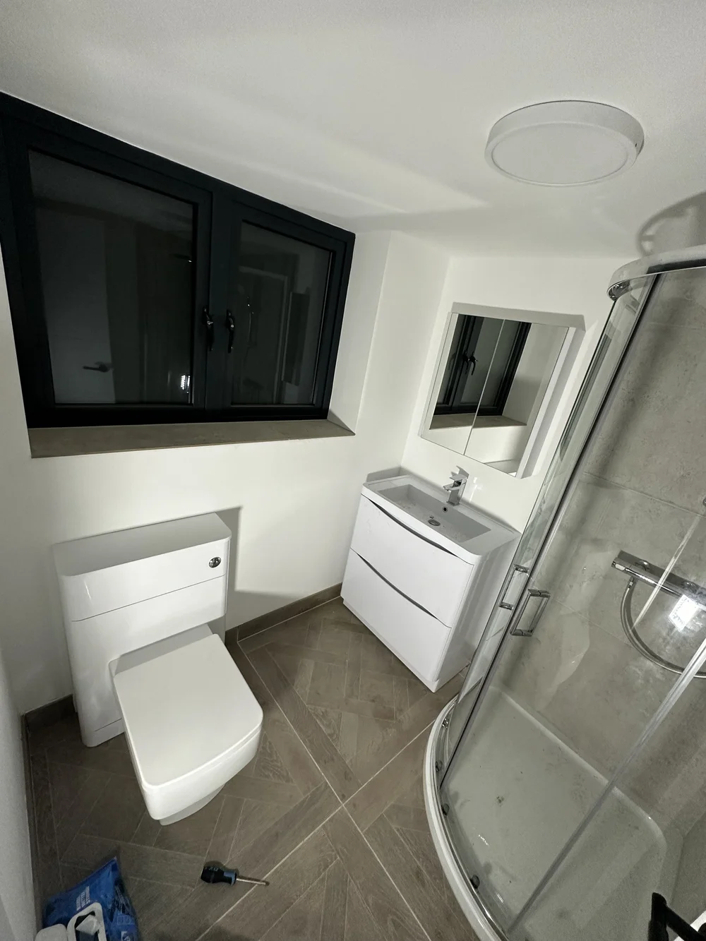 Compact ensuite with quadrant shower enclosure, wall-hung vanity and back-to-wall WC — bathroom installation Haslemere