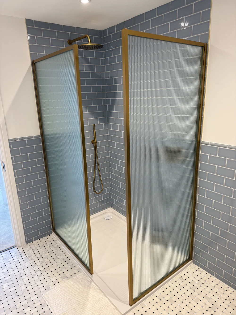 Blue metro tile walk-in shower with brushed brass fluted screens — Haslemere bathroom fitters