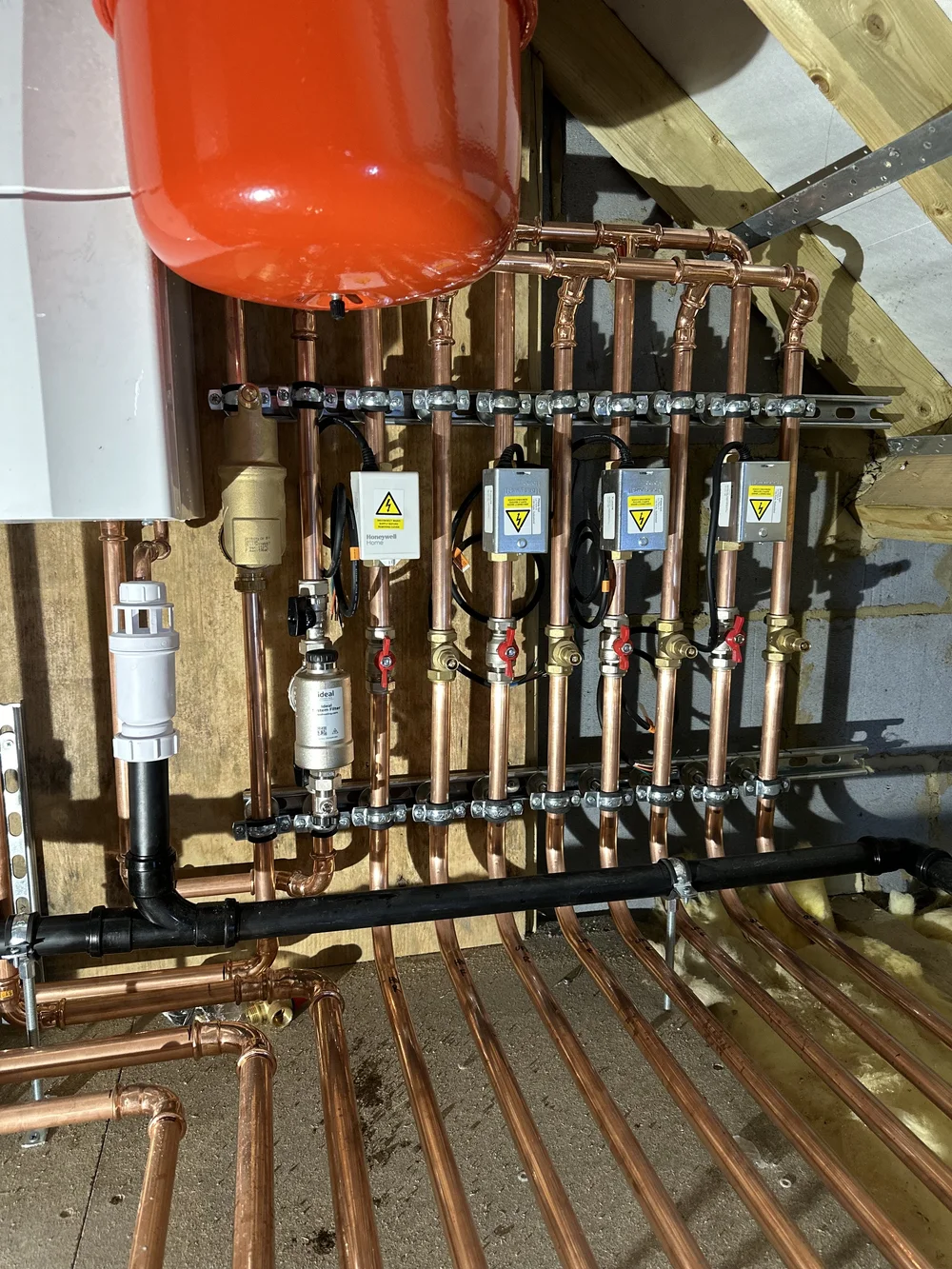 Detailed copper manifold with Honeywell zone controls and Ideal system filter — plumber Haslemere