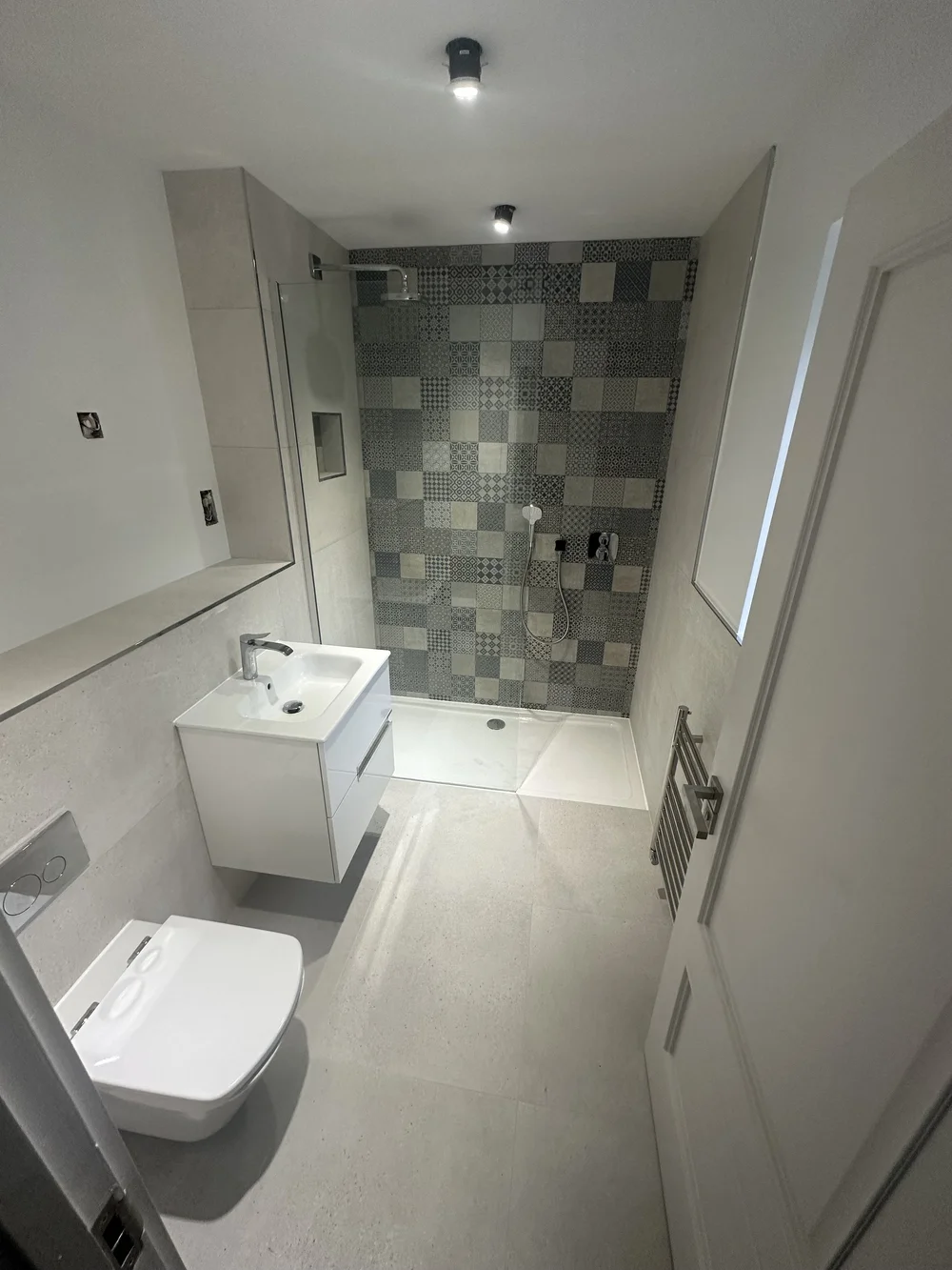Compact shower room with patchwork feature wall and floating white vanity — bathroom installation Haslemere