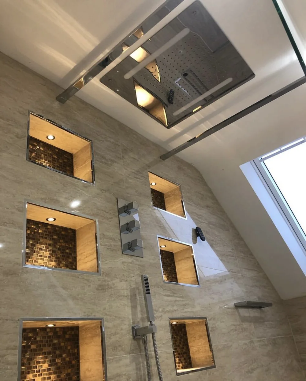 Ceiling rainfall panel with LED strip lighting over travertine walk-in shower — luxury bathroom installation Haslemere
